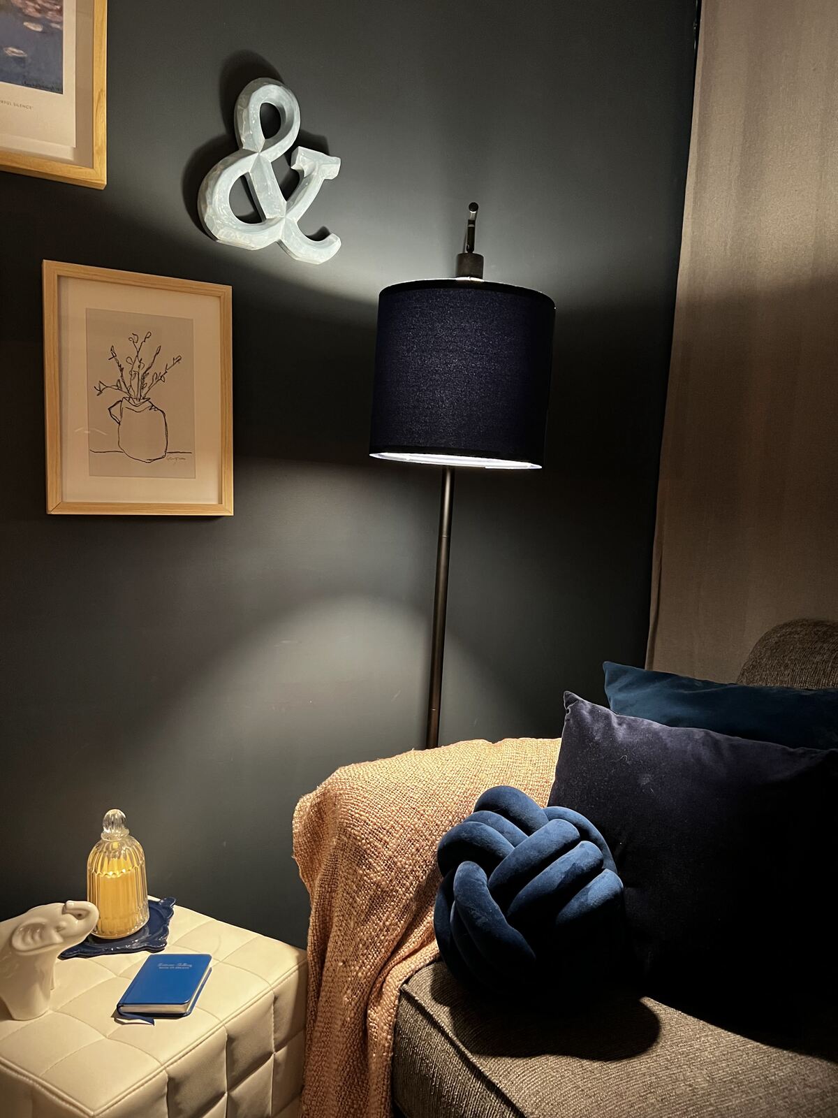 A cozy corner of Tara McKeeman's therapy office in Phoenix, AZ, with warm lamp light, a soft throw, and calming decor